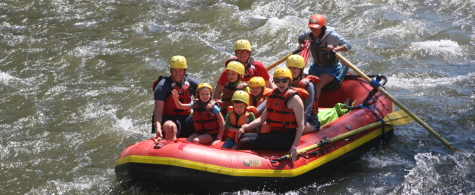 A family having fun in a raft going down the river Raft Masters