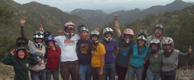 Group of people with helmets on and mountains in the background Raft Masters Tours Colorado