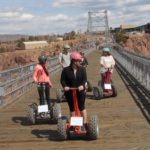 family of five riding segways across the bridge Raft Masters Colorado