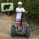 young boy on segway in front of bear sign Raft Masters Colorado