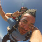 Yisrael with his arms out wide while skydiving Raft Masters Tours Colorado